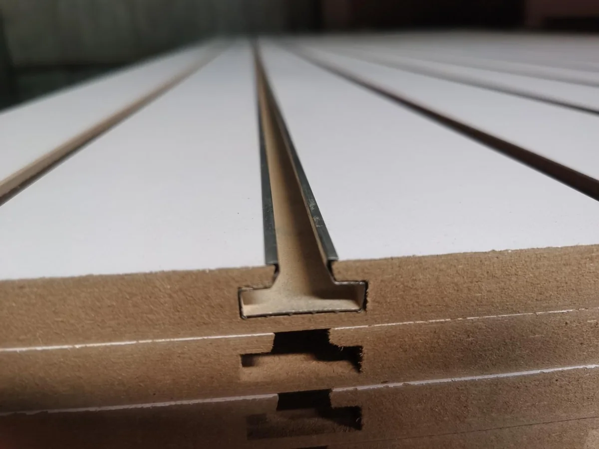 Aluminum channel fitted into the shaped slot of a white melamine MDF panel