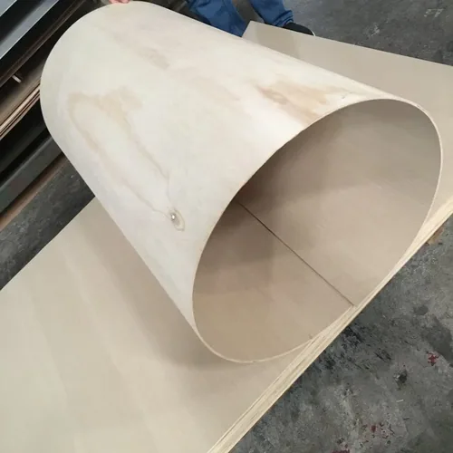 A thin pale plywood sheet bent into a large loop beside a flat sheet.